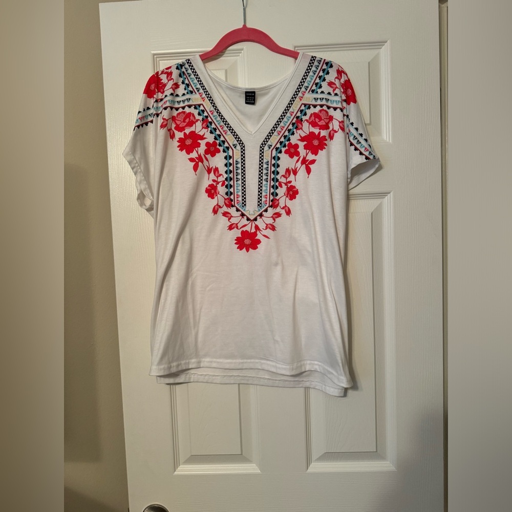 White shirt with floral print around the neck and arms. Size XL